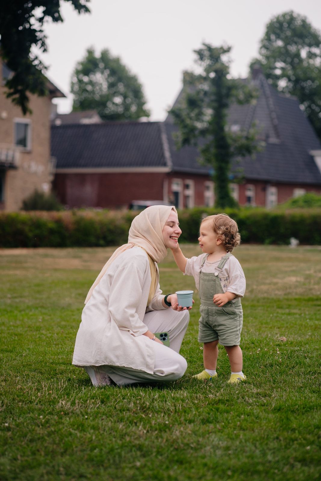 Mother kneeling in a garden with her toddler