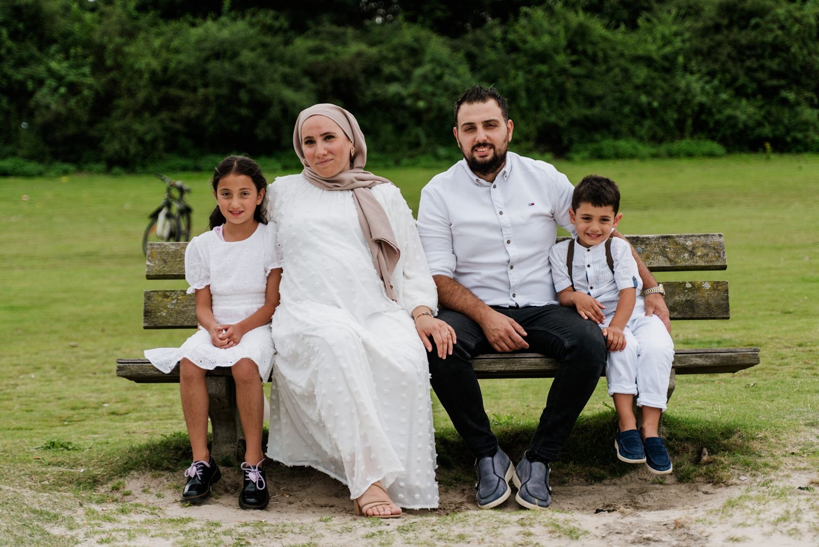 Family sitting together on a park bench