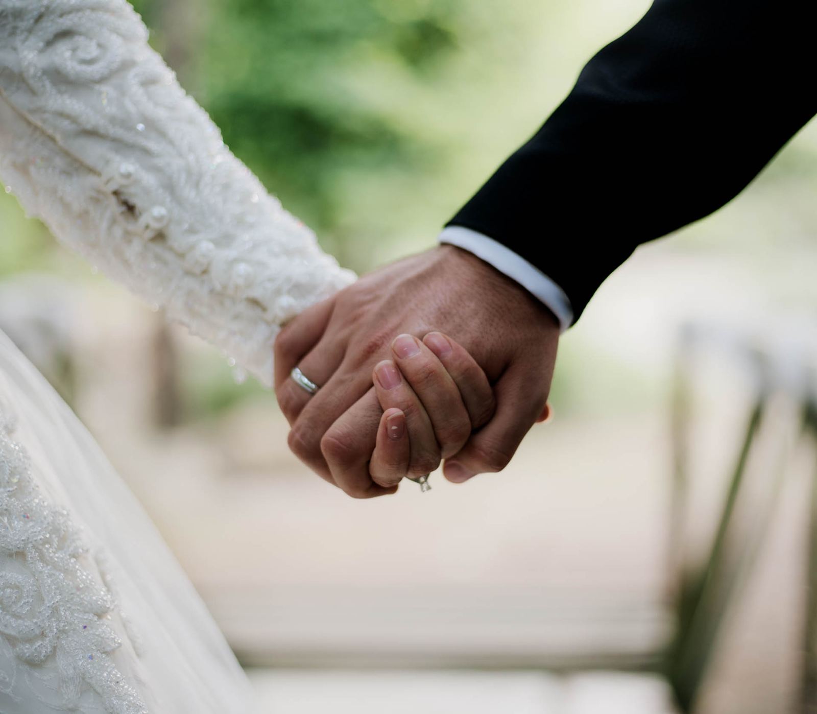 Close-up of a bride and groom holding hands