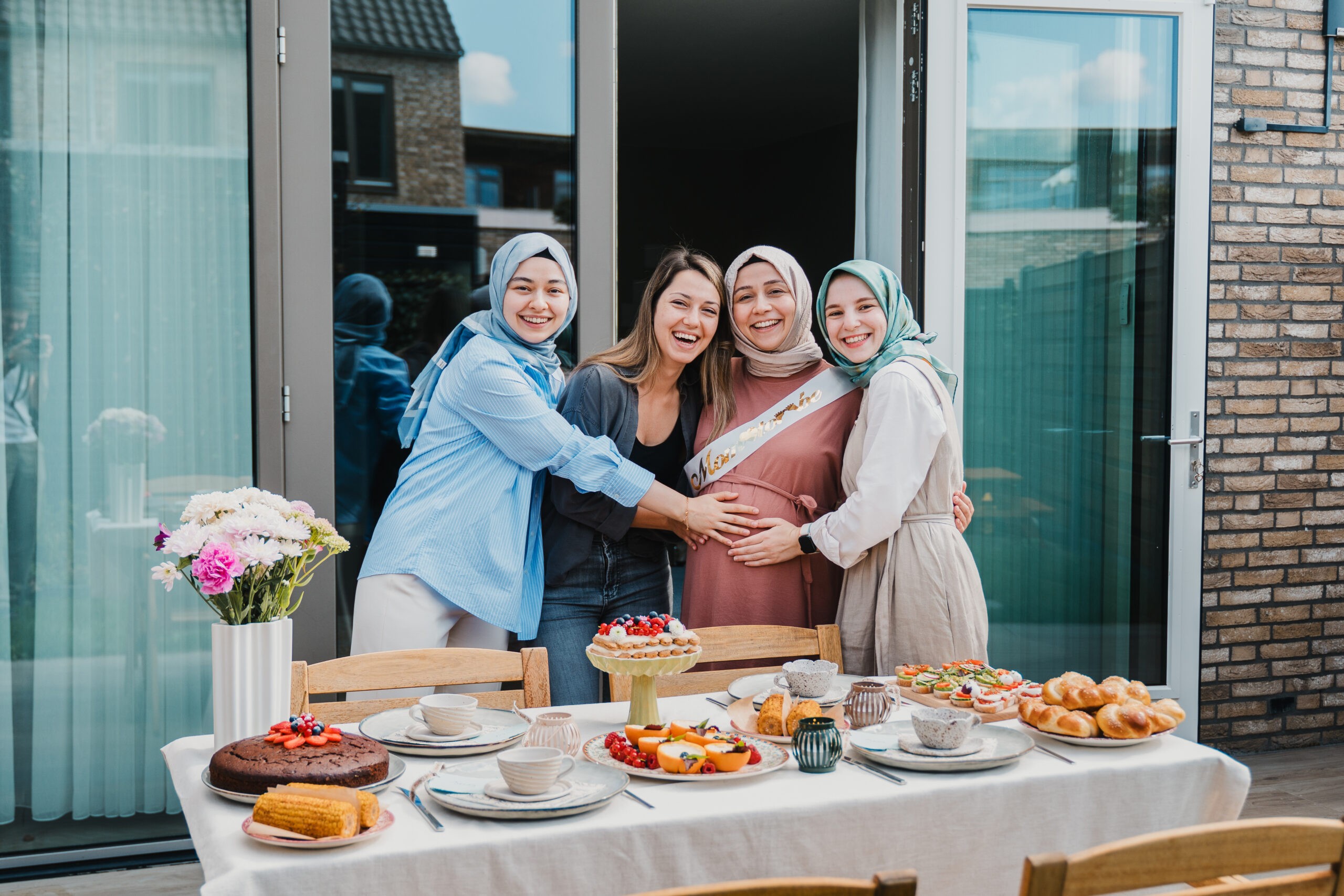 Family gathered around a table set with food on a terrace