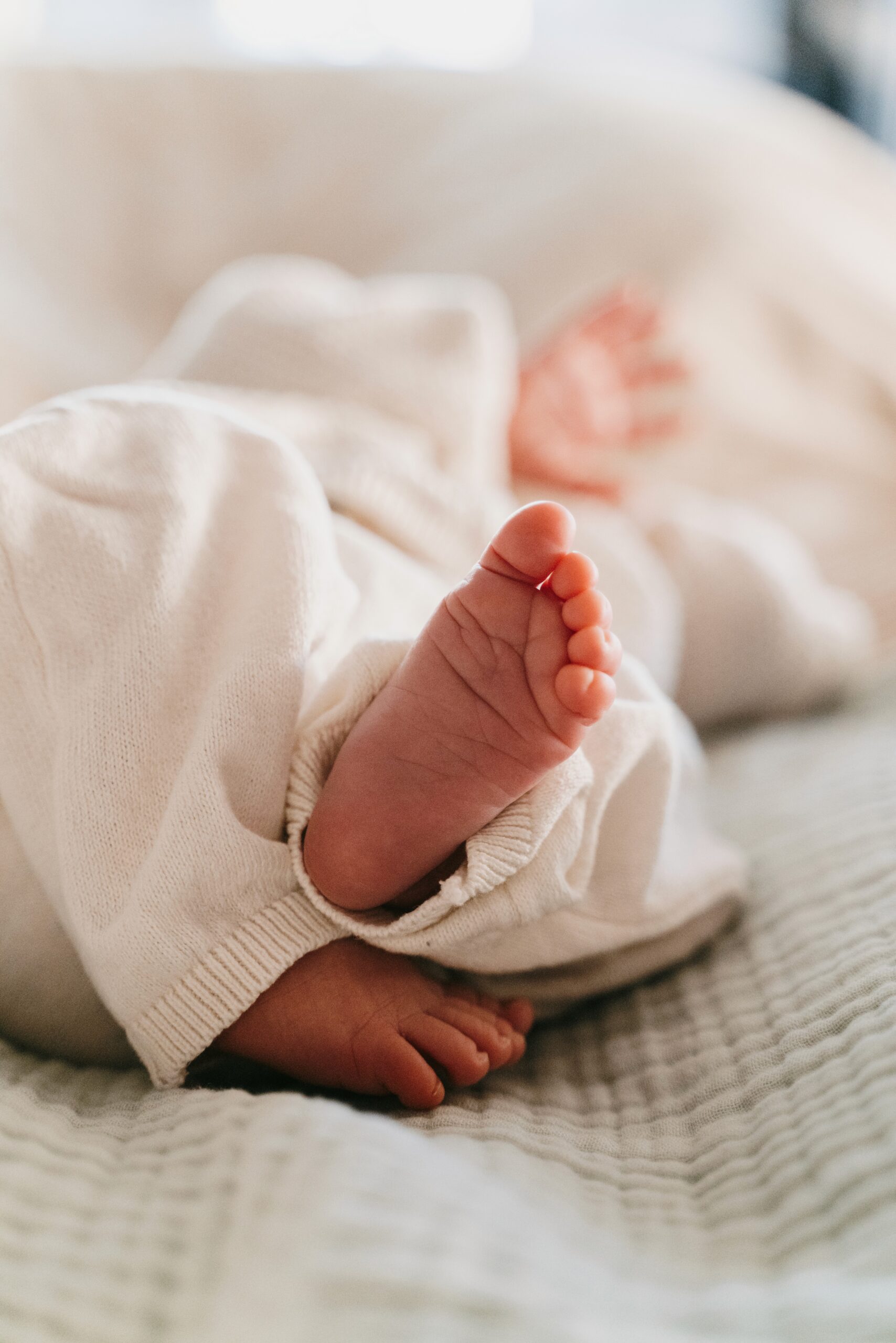 Close-up of a newborn baby's foot in a soft blanket