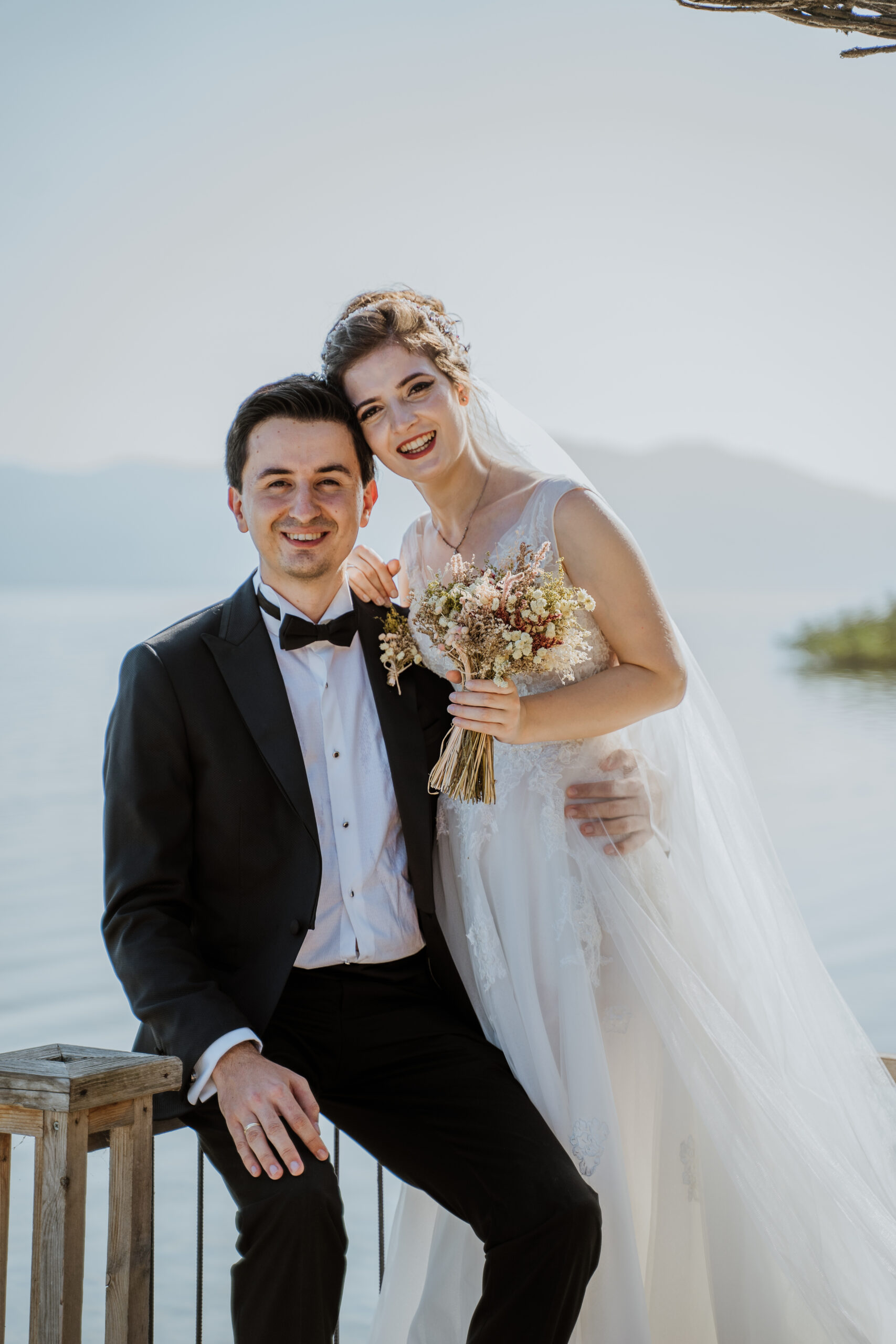 Bride and groom smiling together by a lake