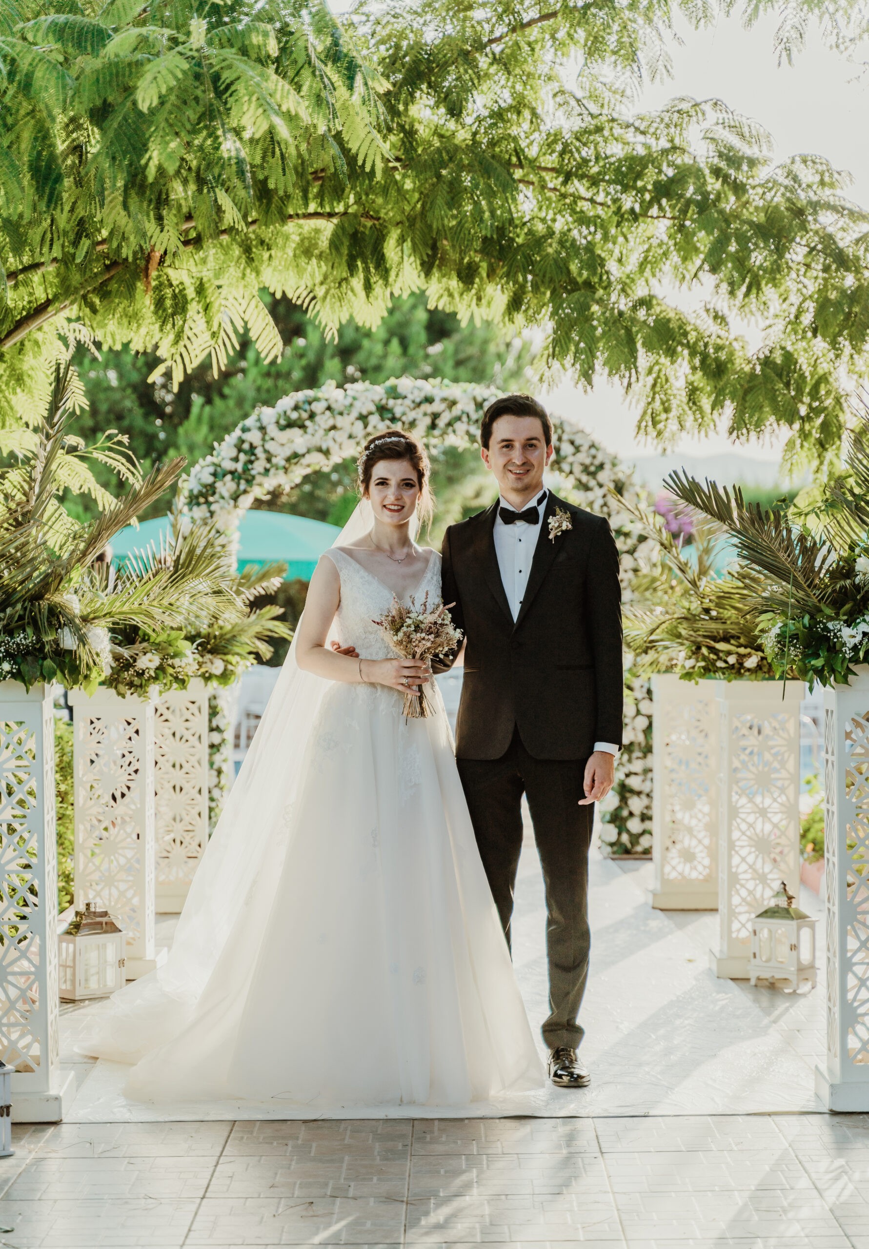 Bride and groom walking under a floral arch